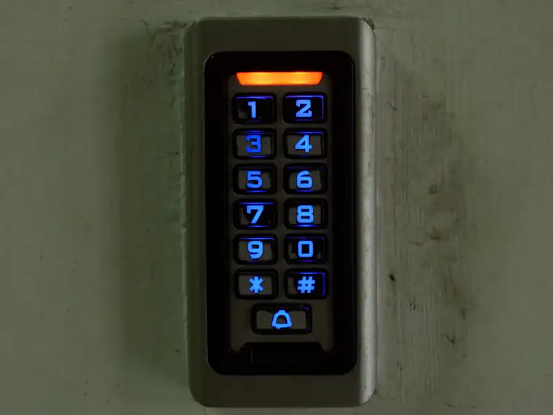 Backlit access keypad mounted beside a building entrance