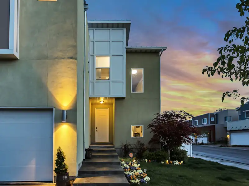Modern house exterior with a lit entrance at dusk