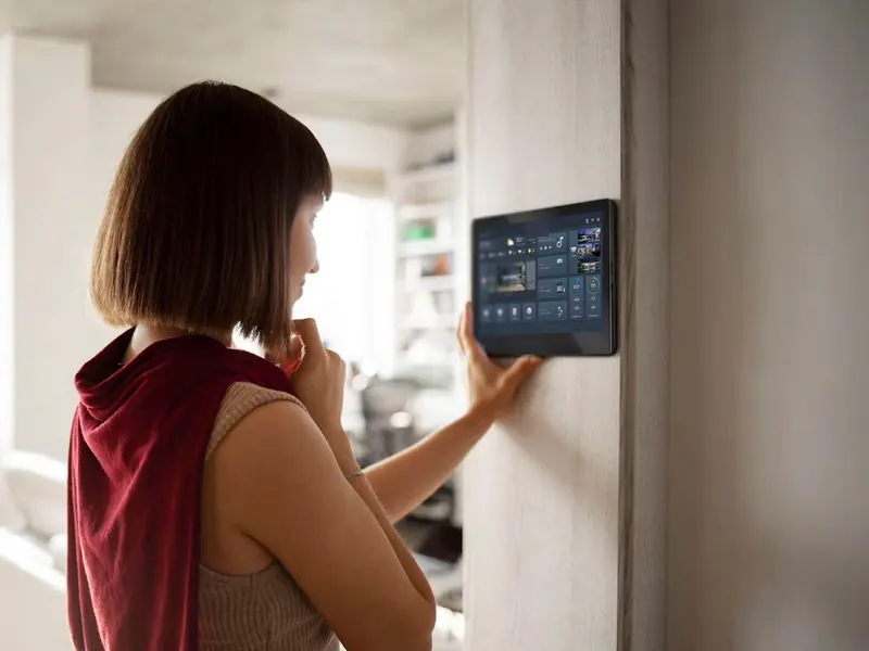 Person using a wall-mounted smart-home touch screen